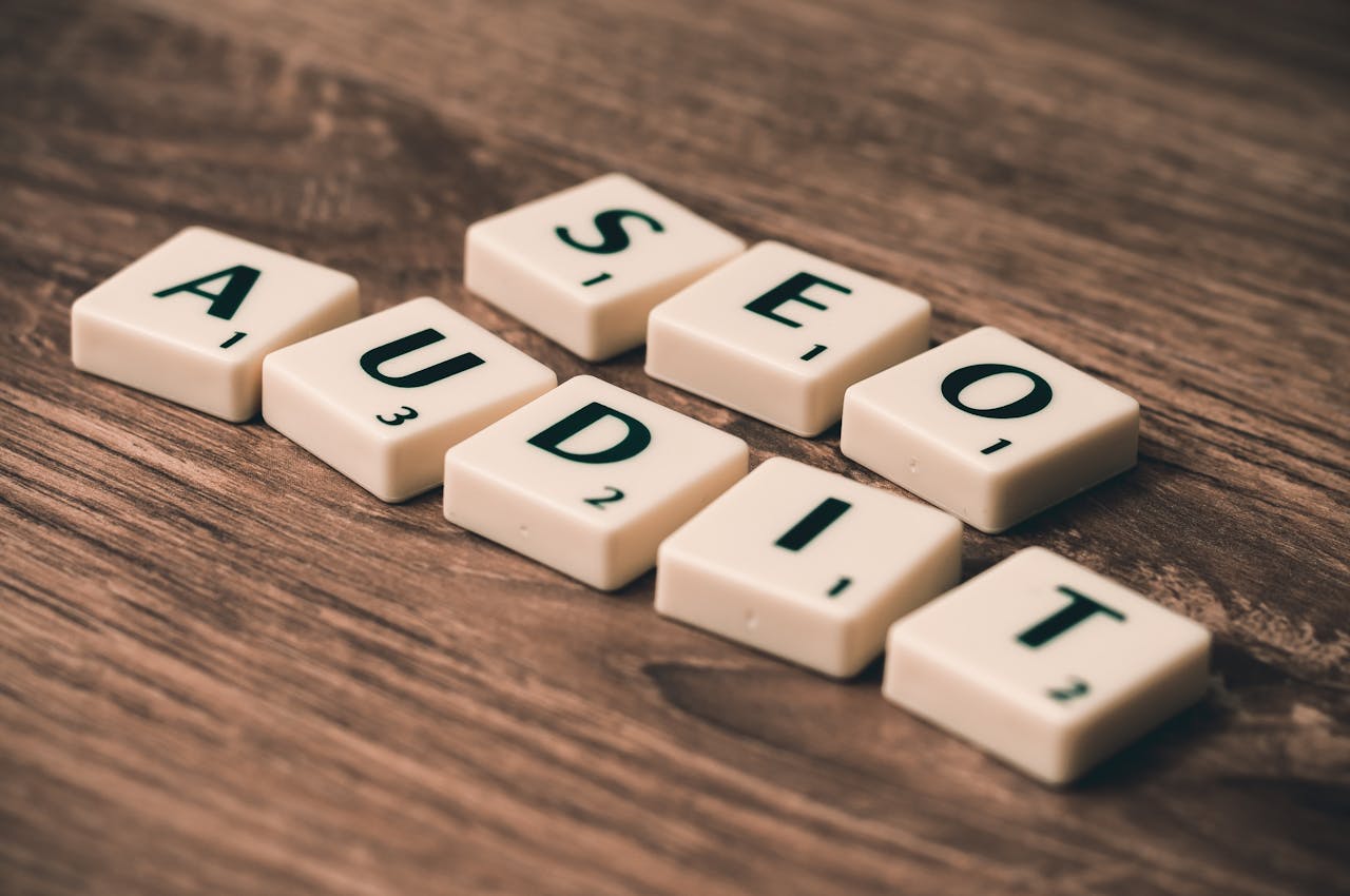 services-04 Scrabble tiles spelling SEO Audit on wooden surface, symbolizing digital marketing strategies.